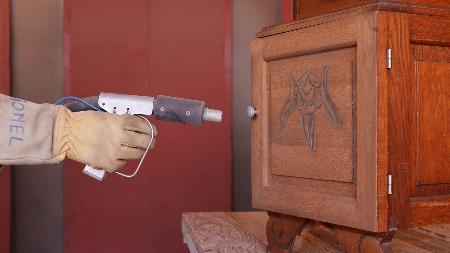 man sandblasting small wood table