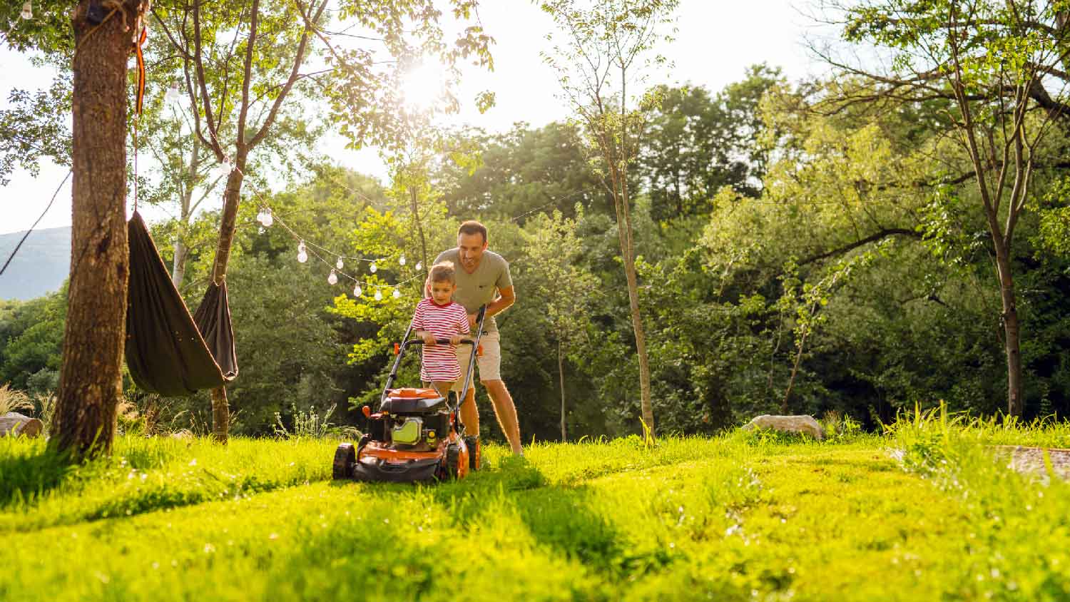 A father mowing the lawn with his son