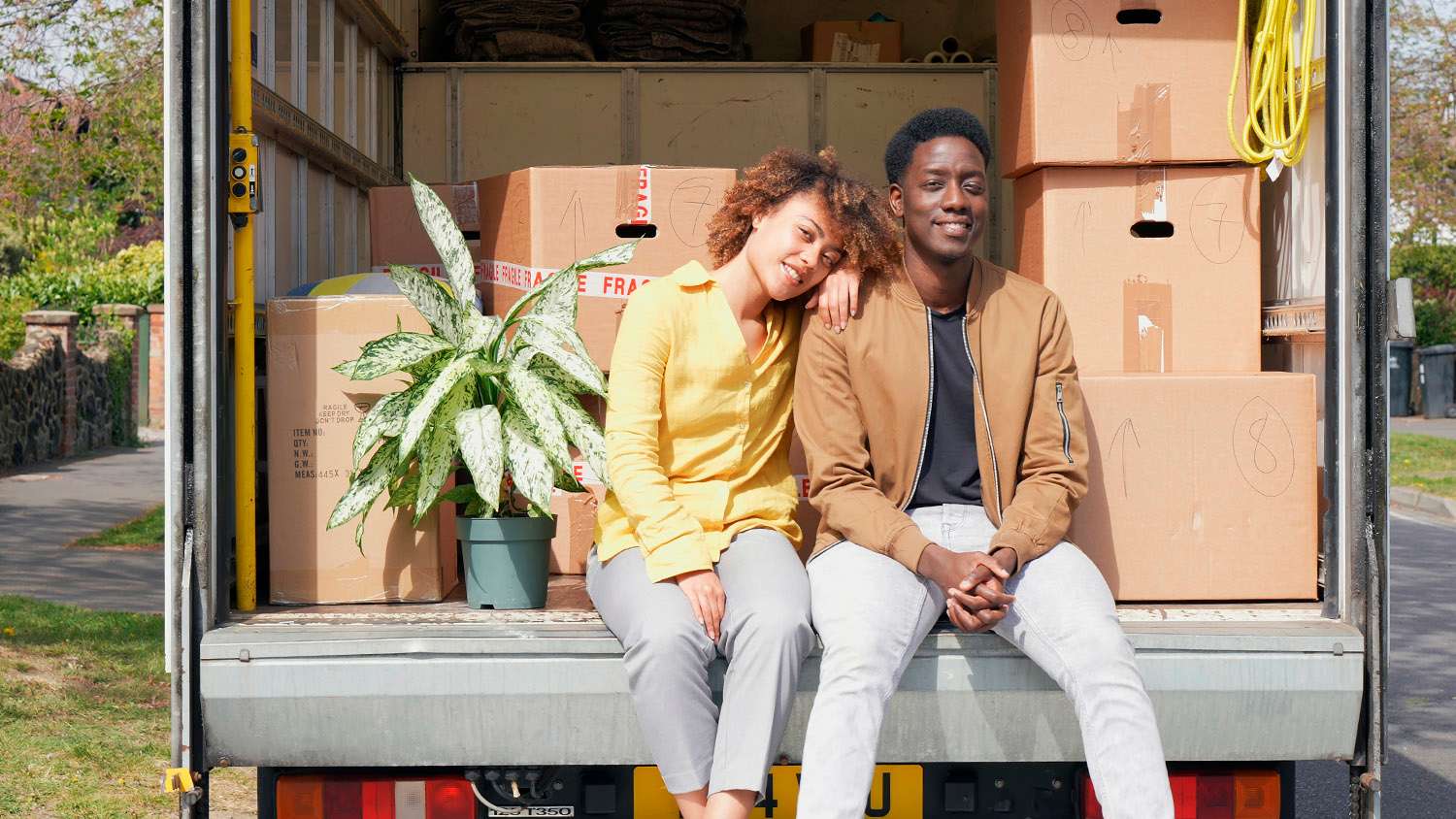 couple sitting in the back of moving truck