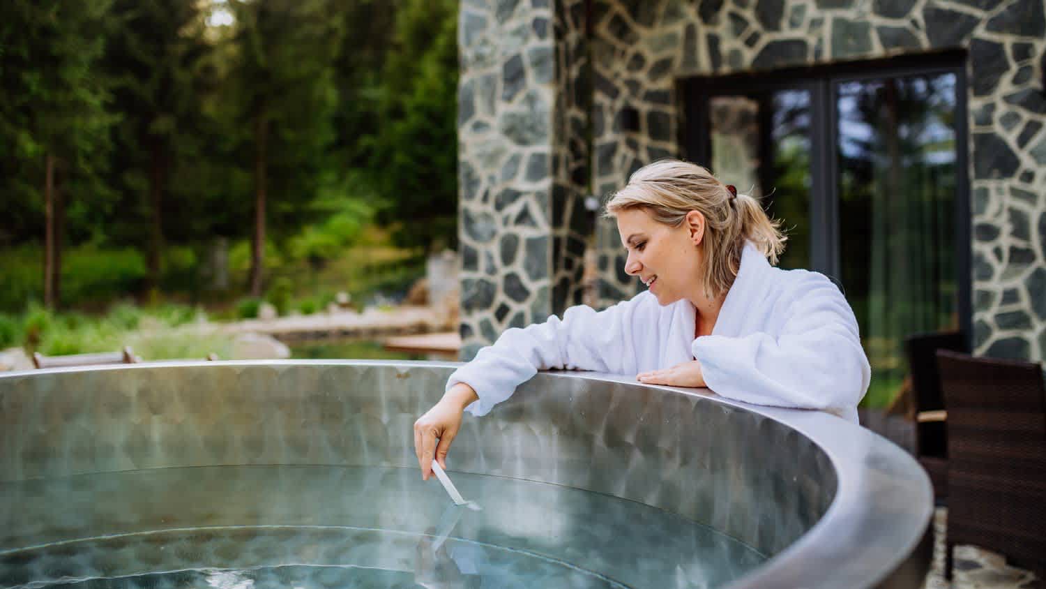 woman testing hot tub temperature