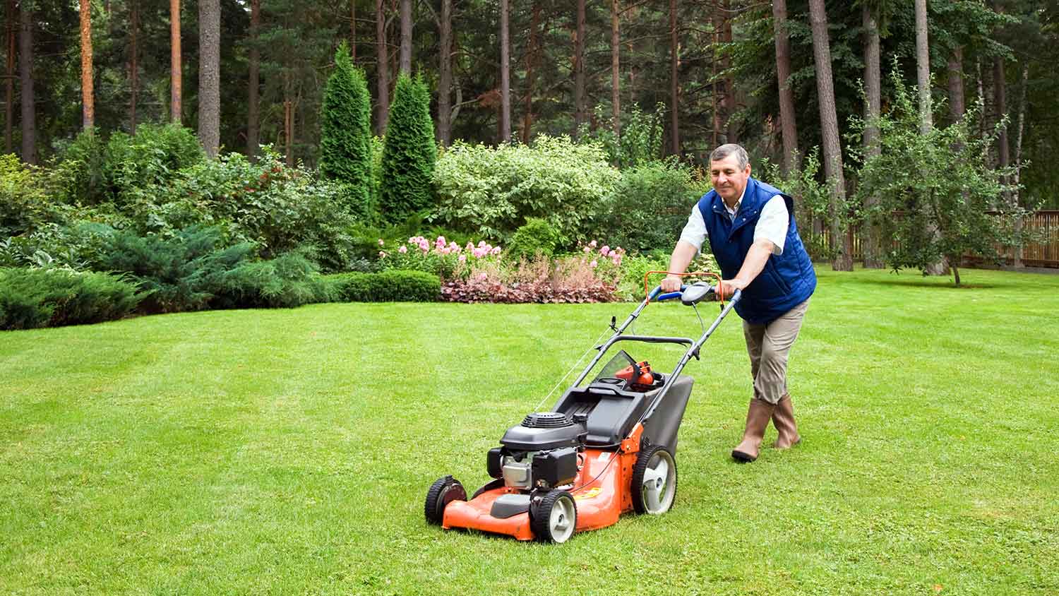 Senior man mowing the lawn at home