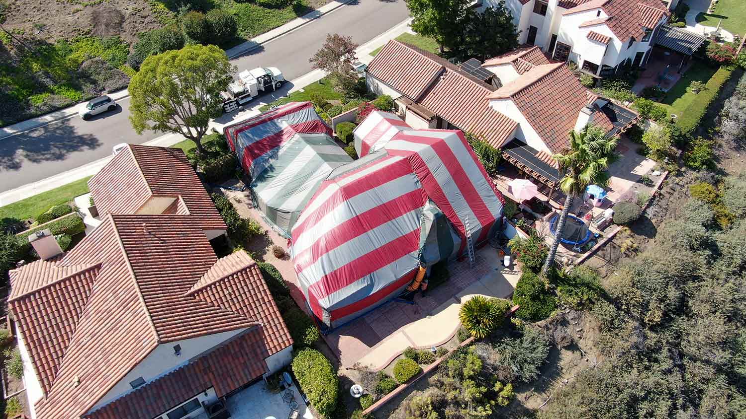 Aerial of house covered with termite fumigation tent.