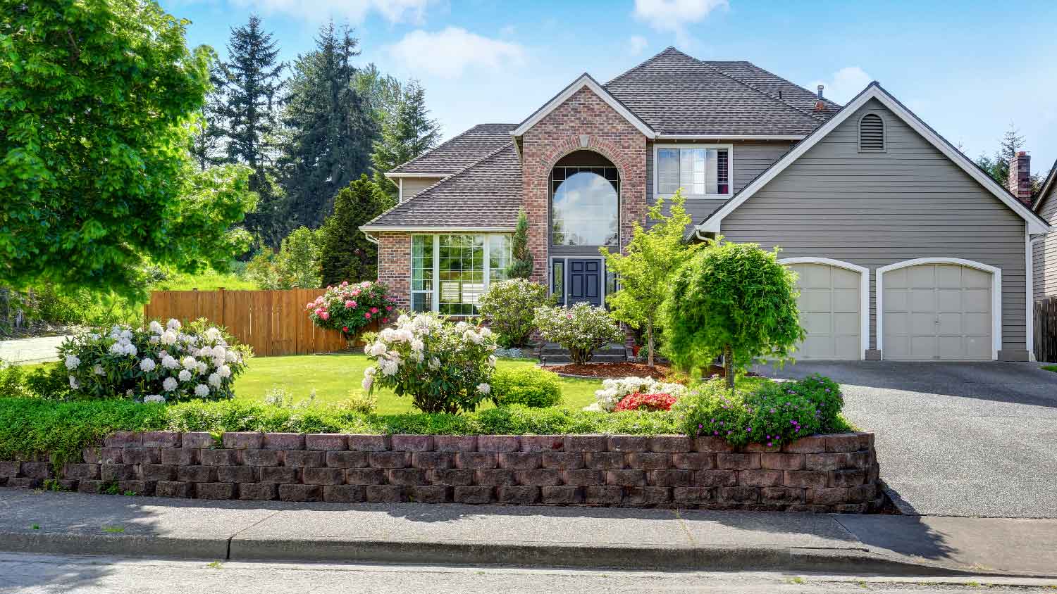 The exterior of a brick house with siding on the garage