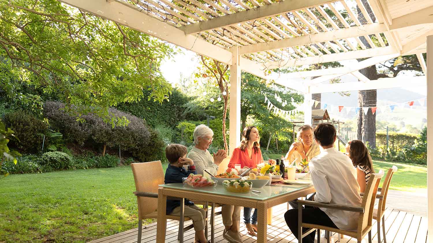 Family enjoying a meal under the pergola