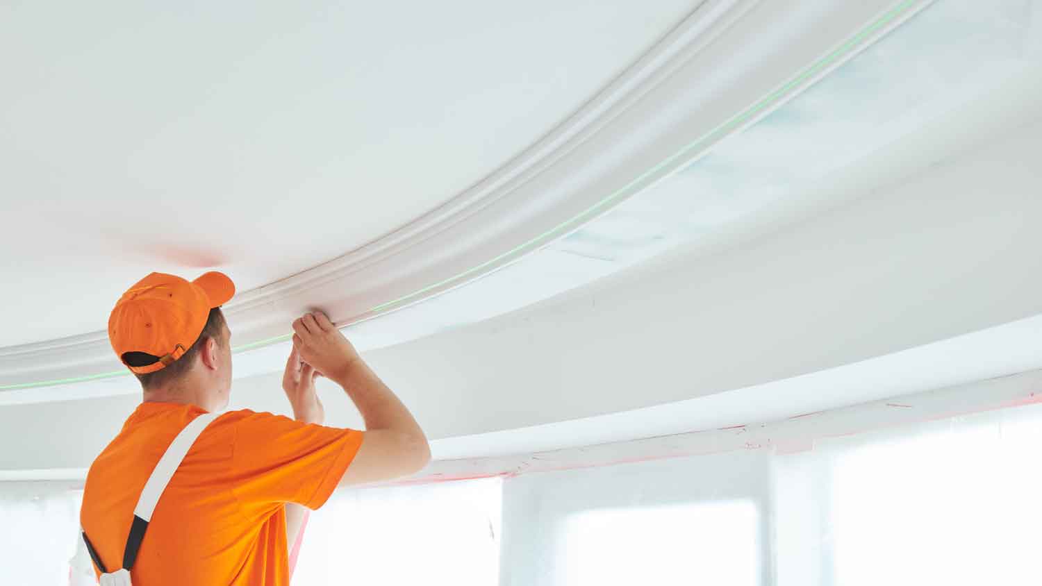 Worker installing flex crown molding in the room