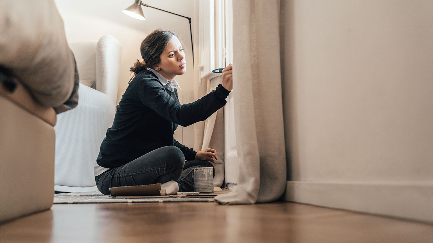 A woman paints trim