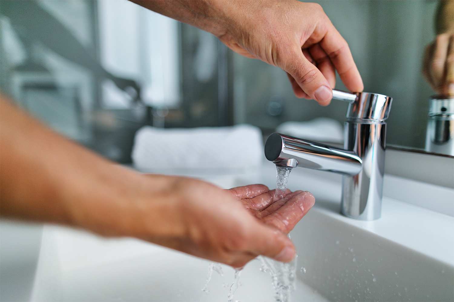 Man checking hot water from sink