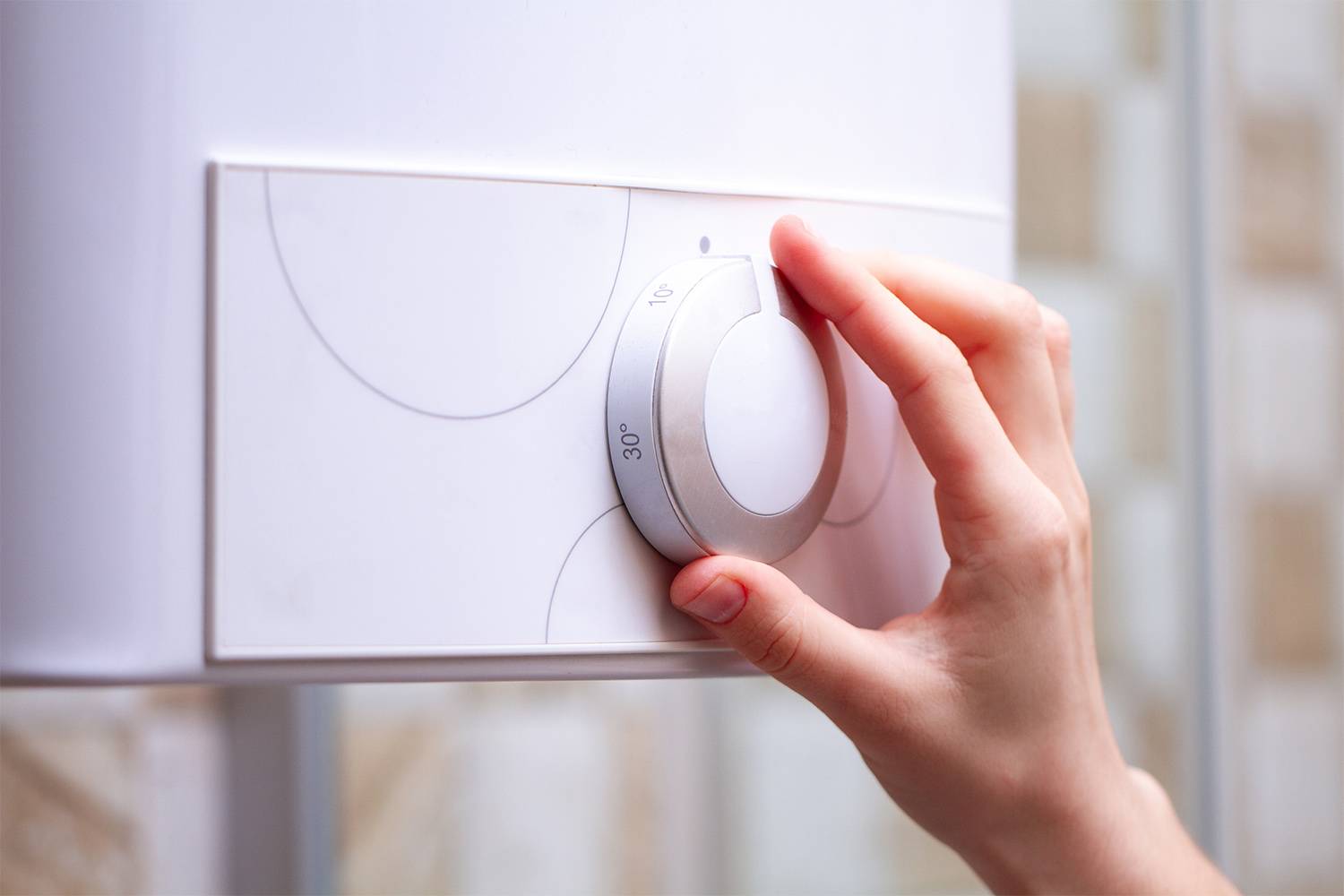 Person adjusting water heater temperature