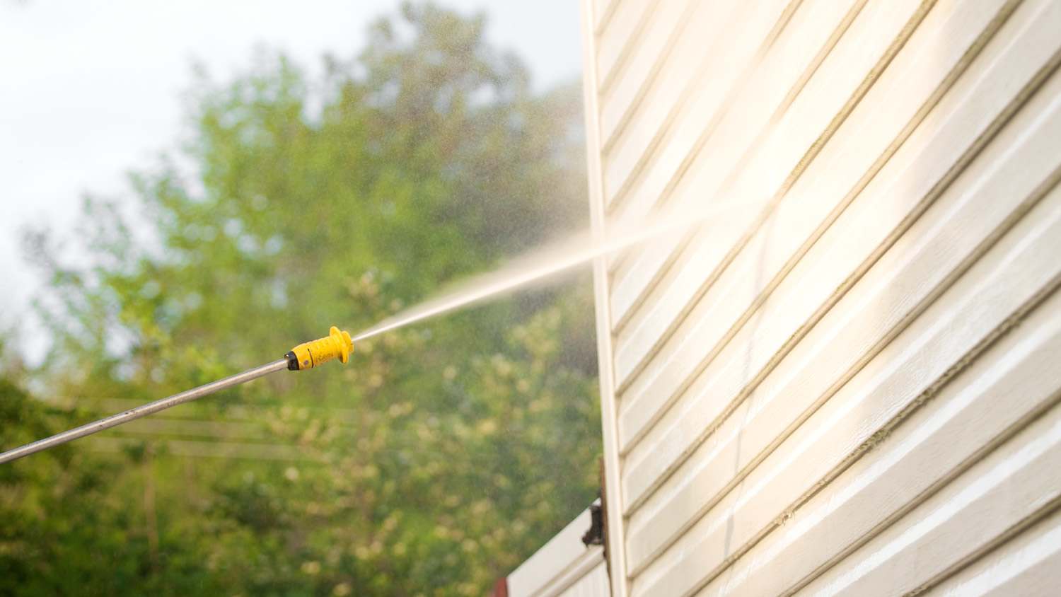Detail of pressure washing the siding of a house