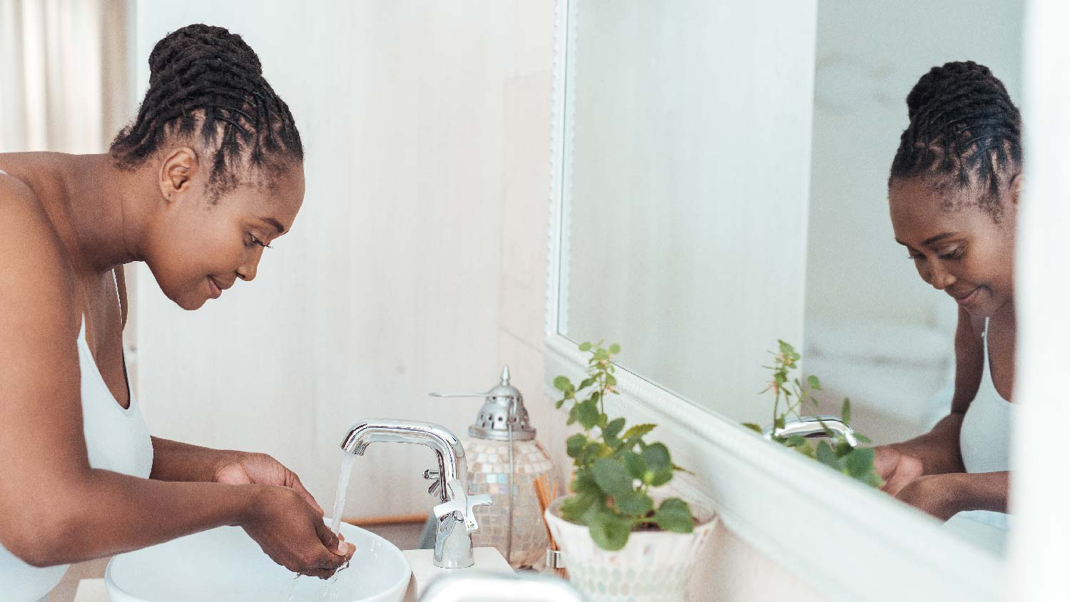 A young woman washing her face in the bathroom