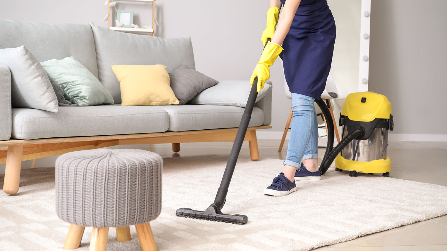 Cleaner vacuums area rug in modern living room