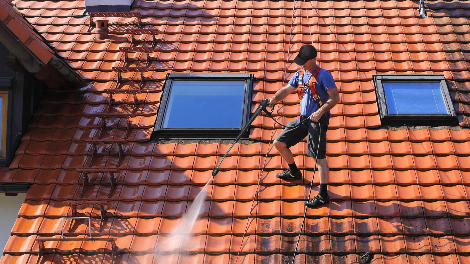 A professional cleaning a roof from dust and debris