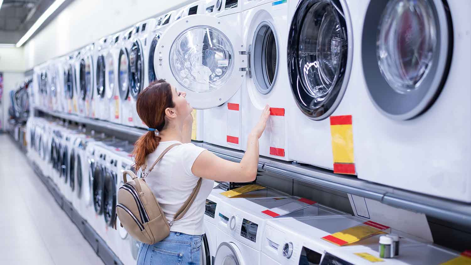 Woman in a department store looking at a clothes dryer