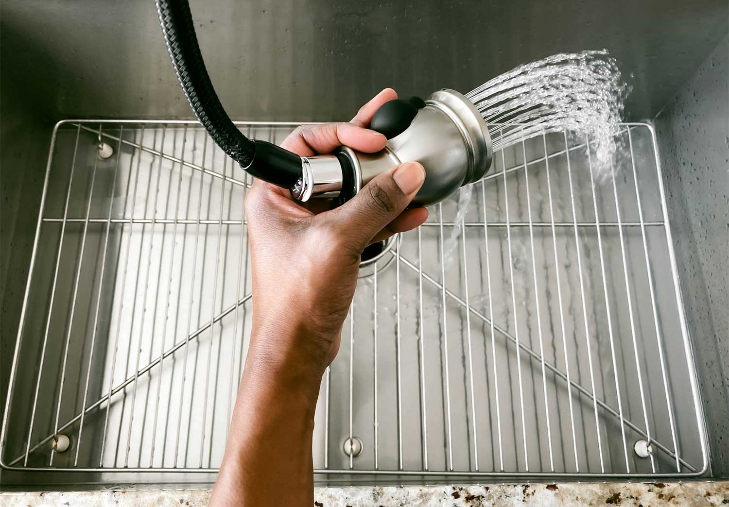 Close up of a woman rinsing kitchen sink