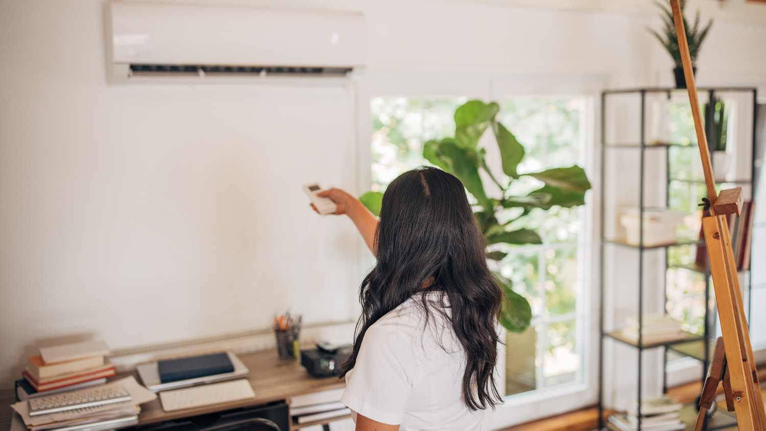 Woman turning on air conditioner