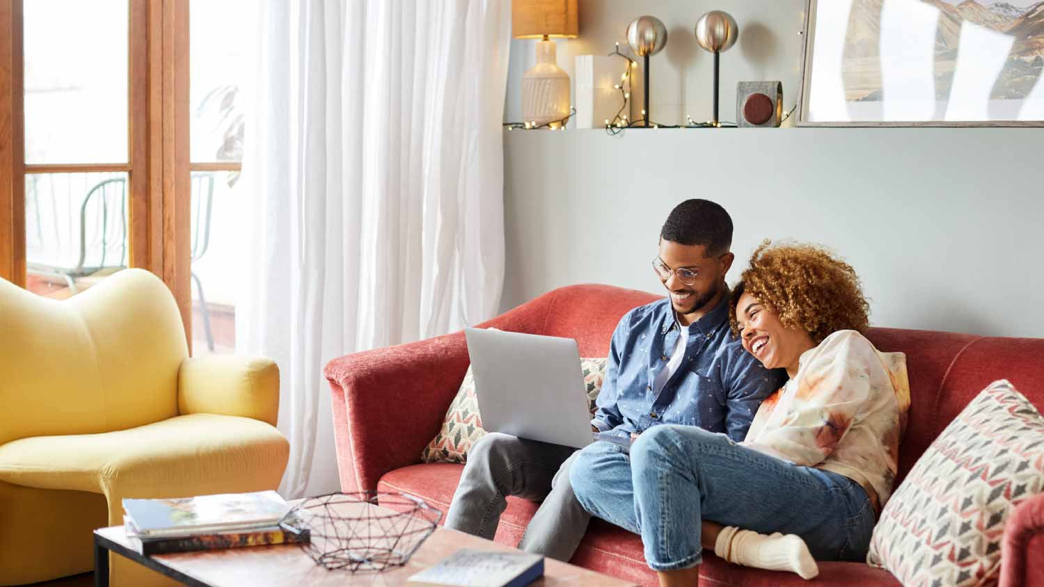 Couple using laptop in living room
