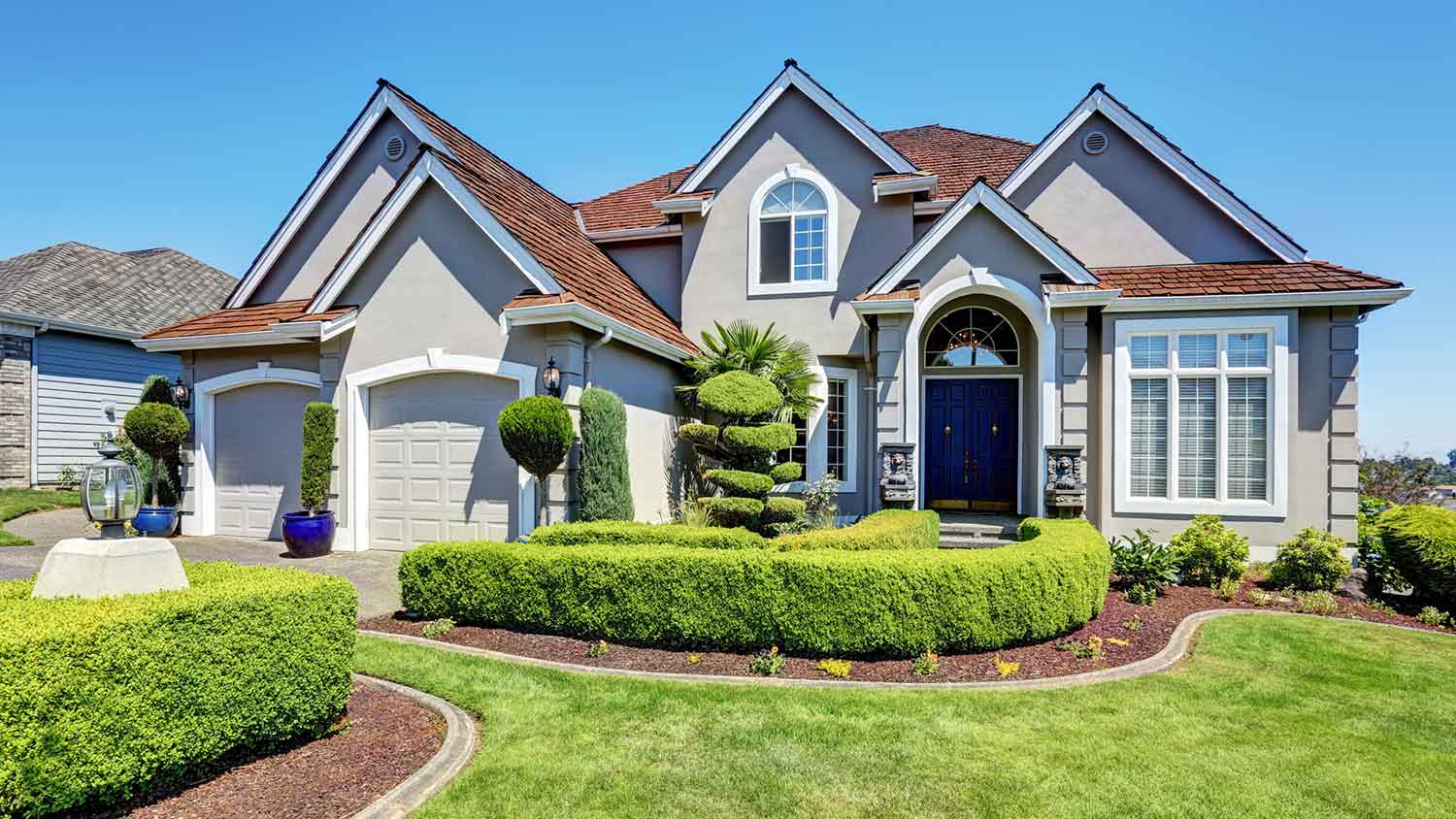 Large house with bushes in the yard