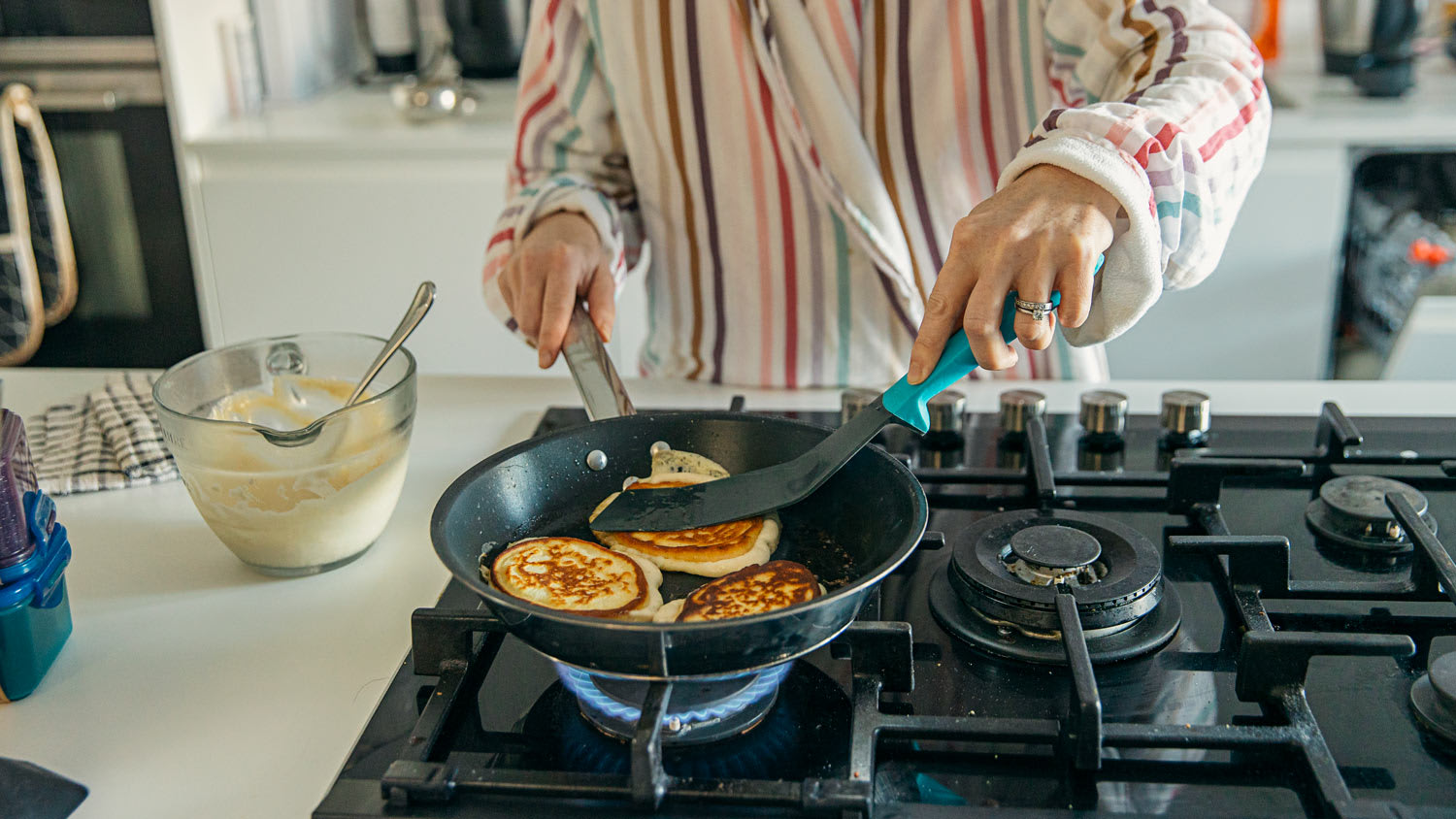 Woman cooking homemade pancakes for breakfast
