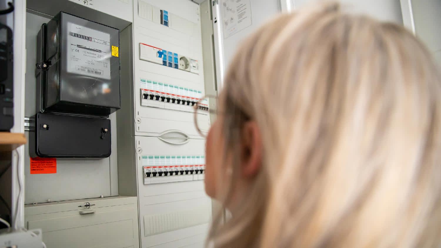 A woman standing in front of an electrical panel