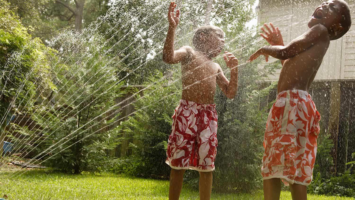 Kids playing in sprinkler water