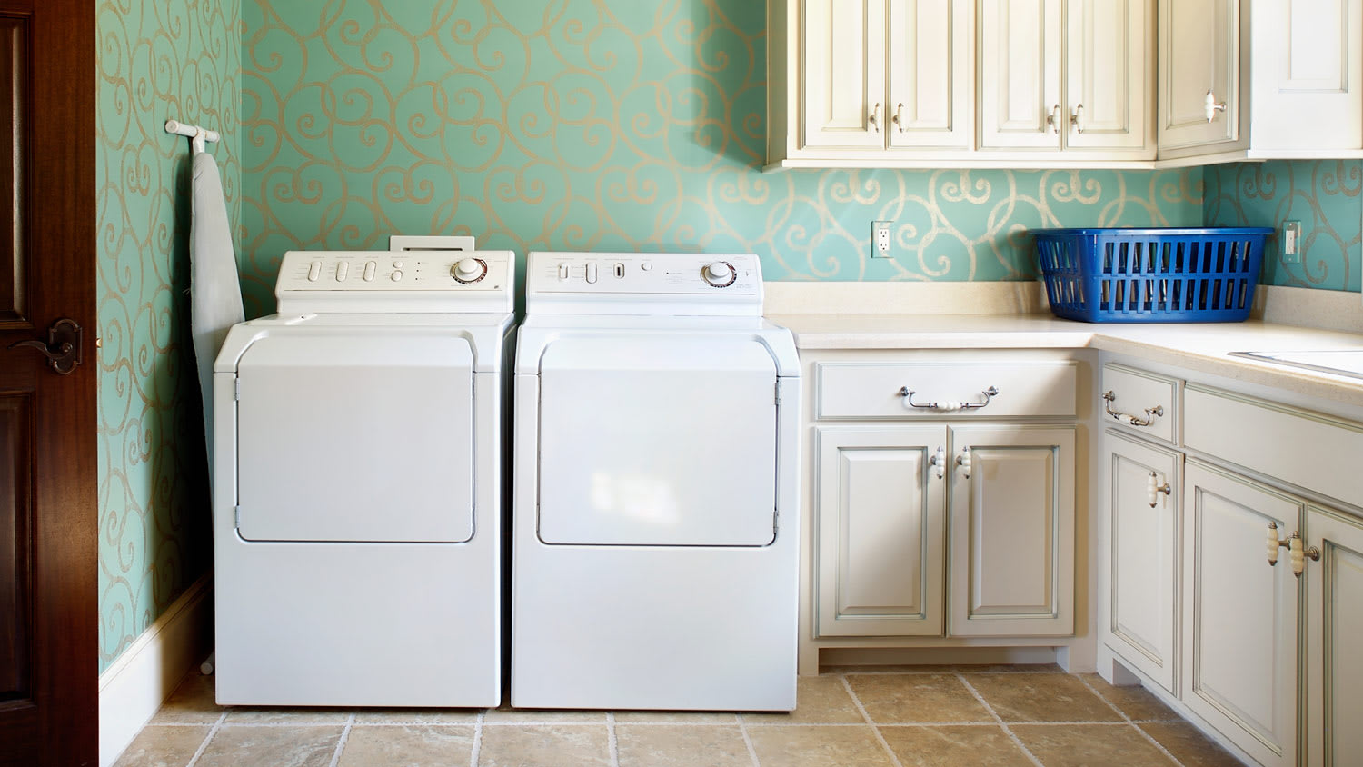 A laundry room with white cabinets