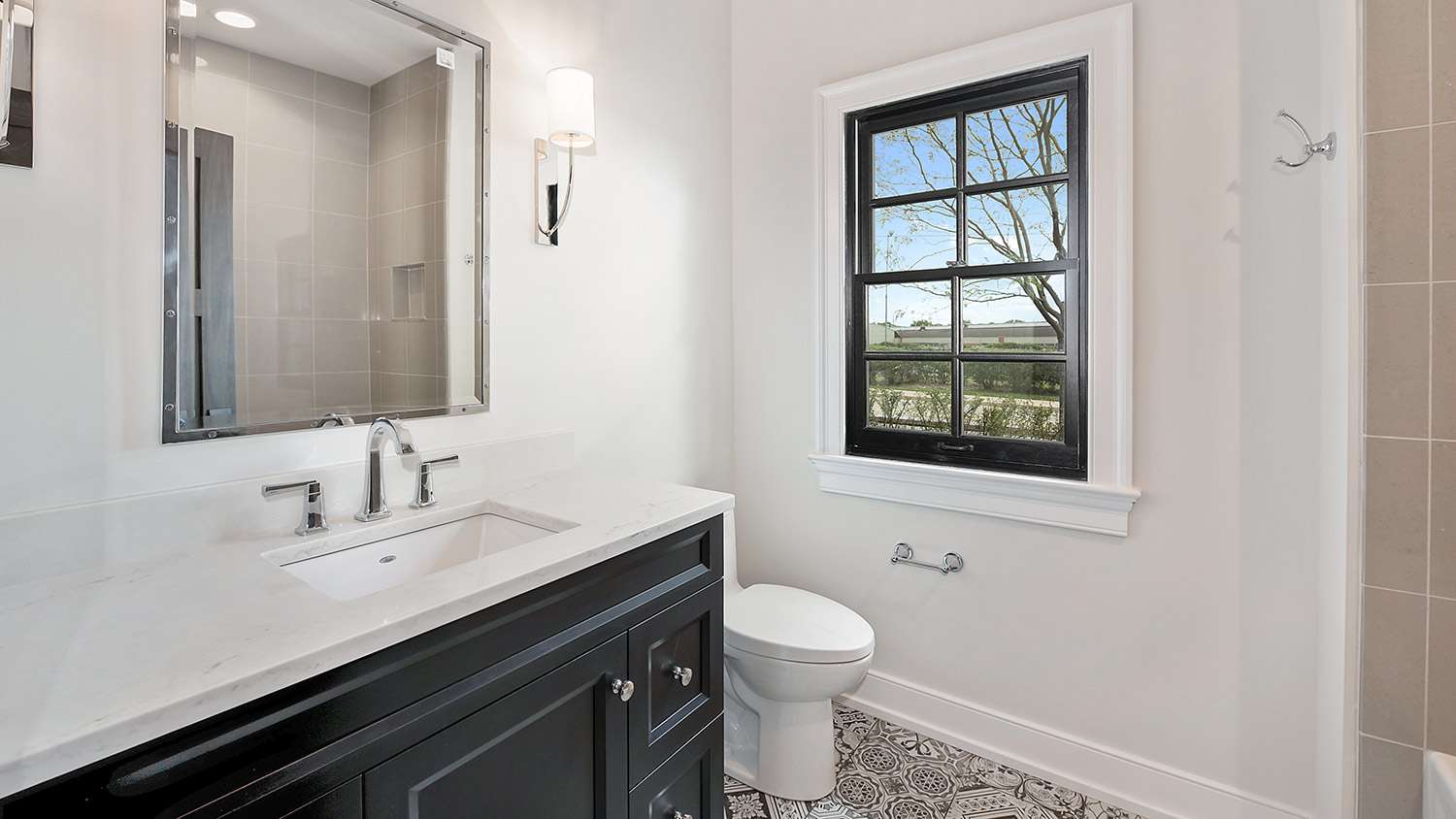 Small, pretty bathroom with black and white tile floors