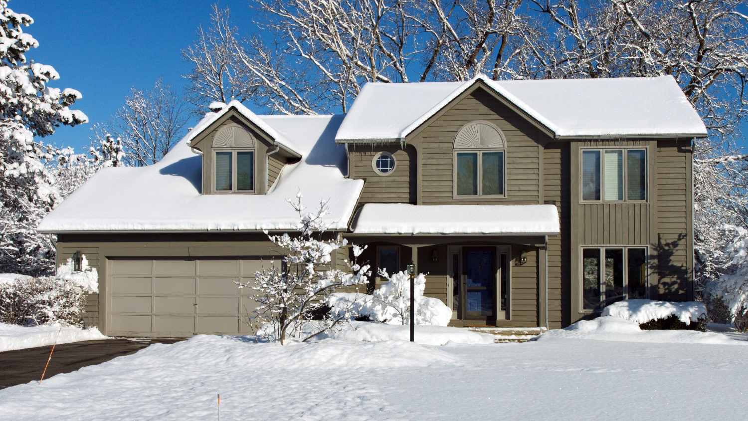 suburban home covered in snow in the winter