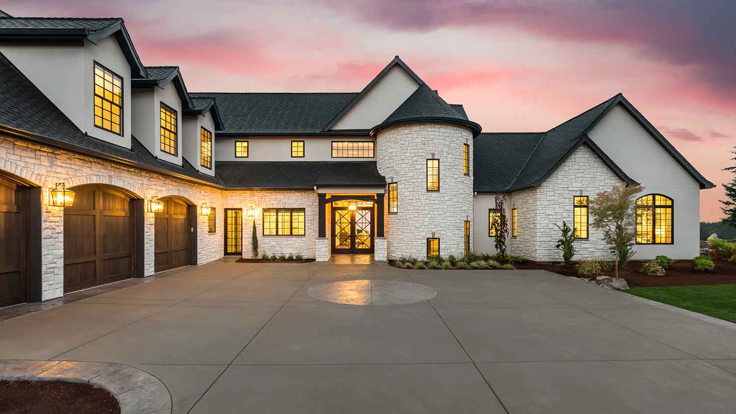 Exterior of a luxury house with lights on during the sunset