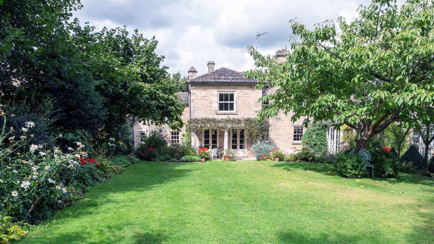 A house with a large backyard having a beautiful lawn