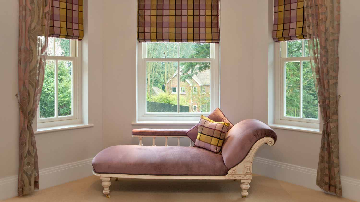 A traditional pink sofa in the bay window