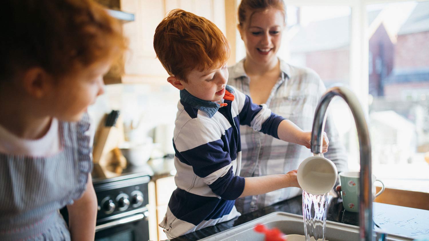 children washing dishes with mom