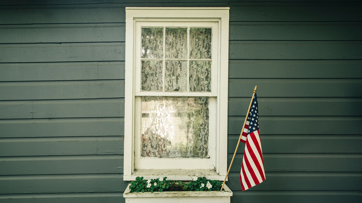 Window box with an American flag outside a house