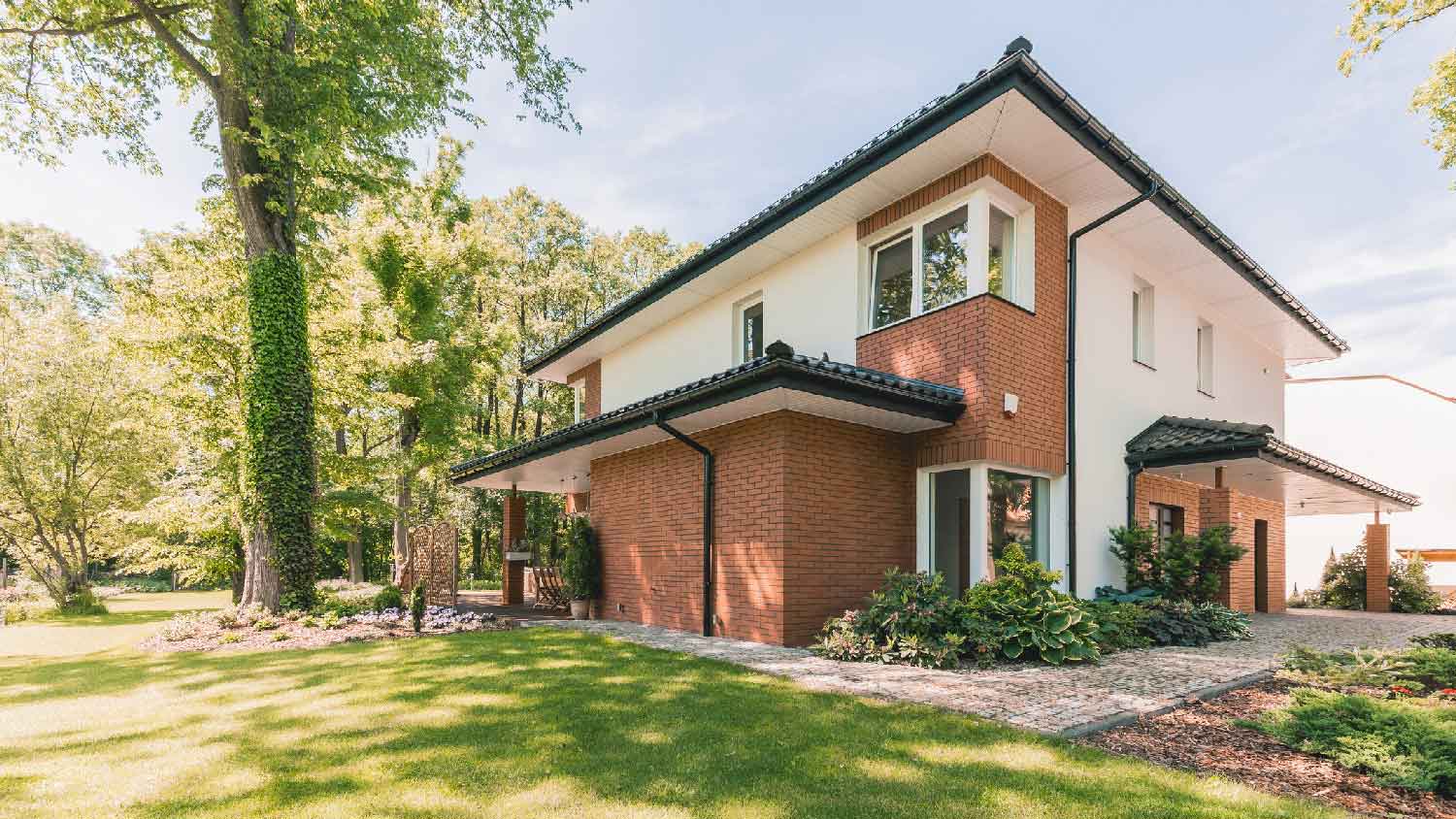 The exterior of a house with a large garden with beautiful lawn
