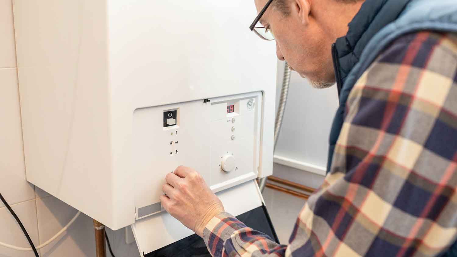 Man lowering water heater temperature