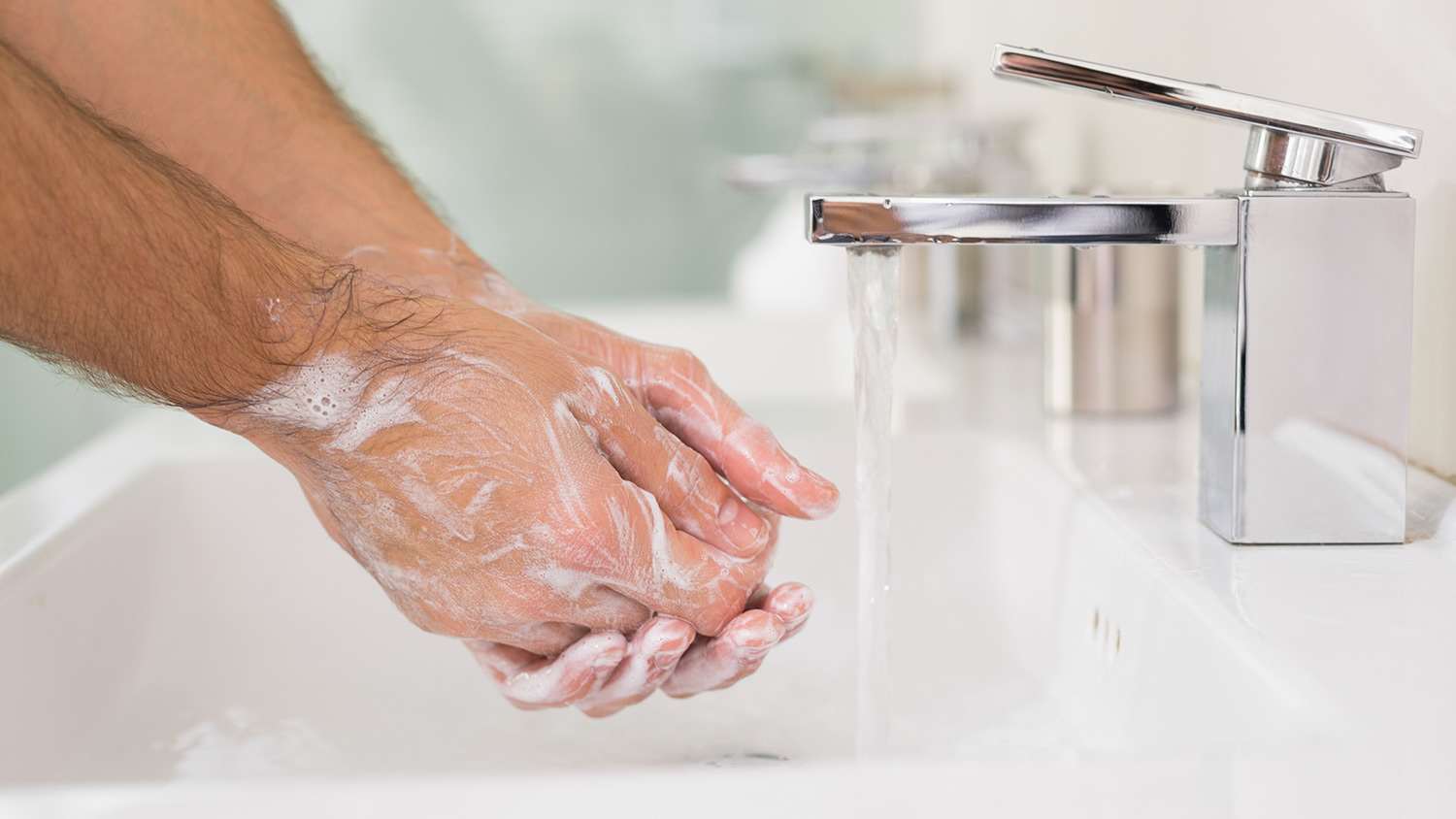 Washing hands with soap under running water