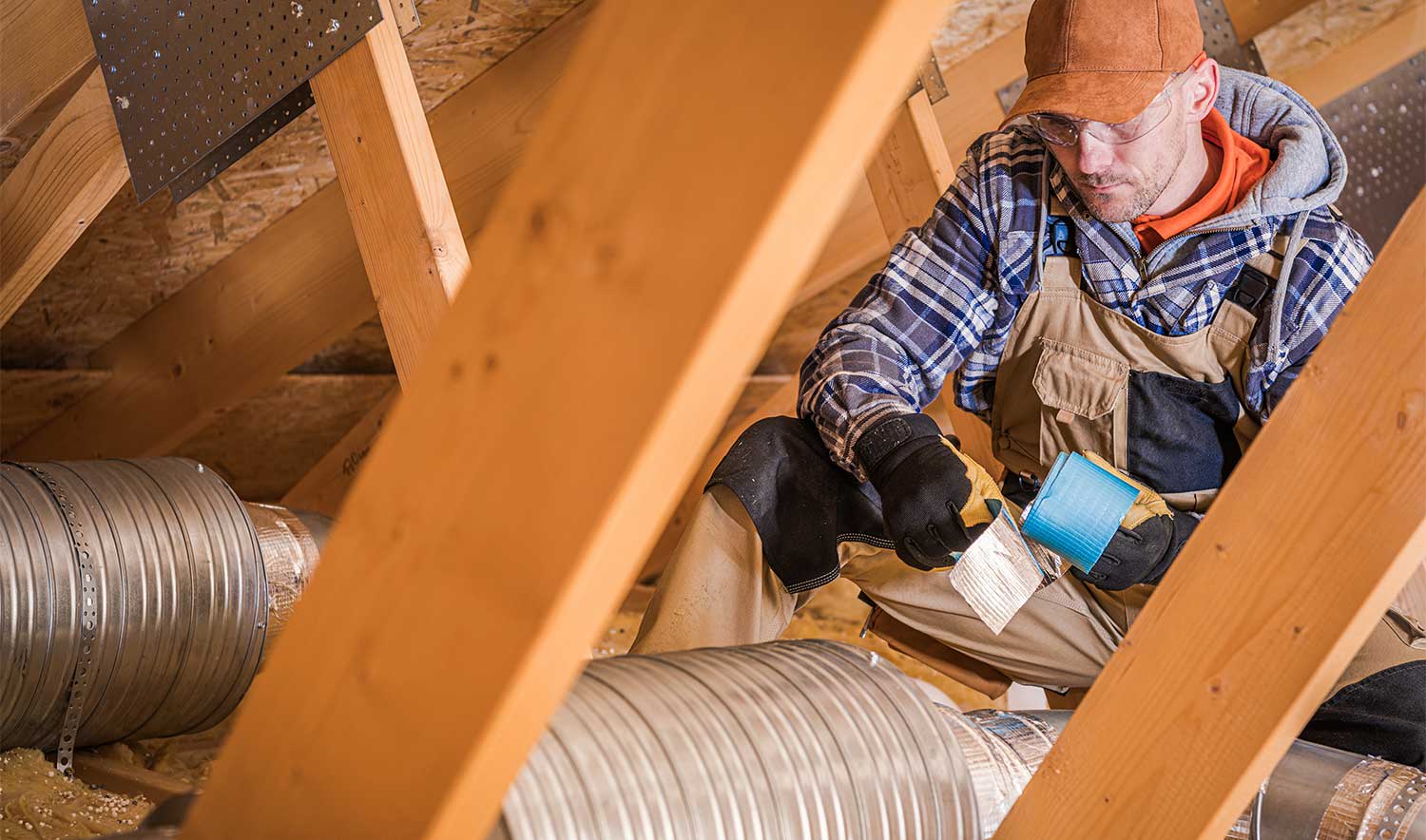 contractor assembling hvac pipes in attic