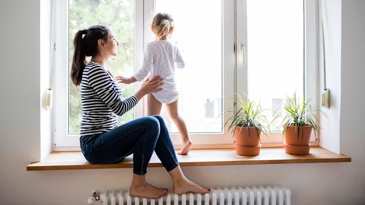 A mother with her daughter looking out the window