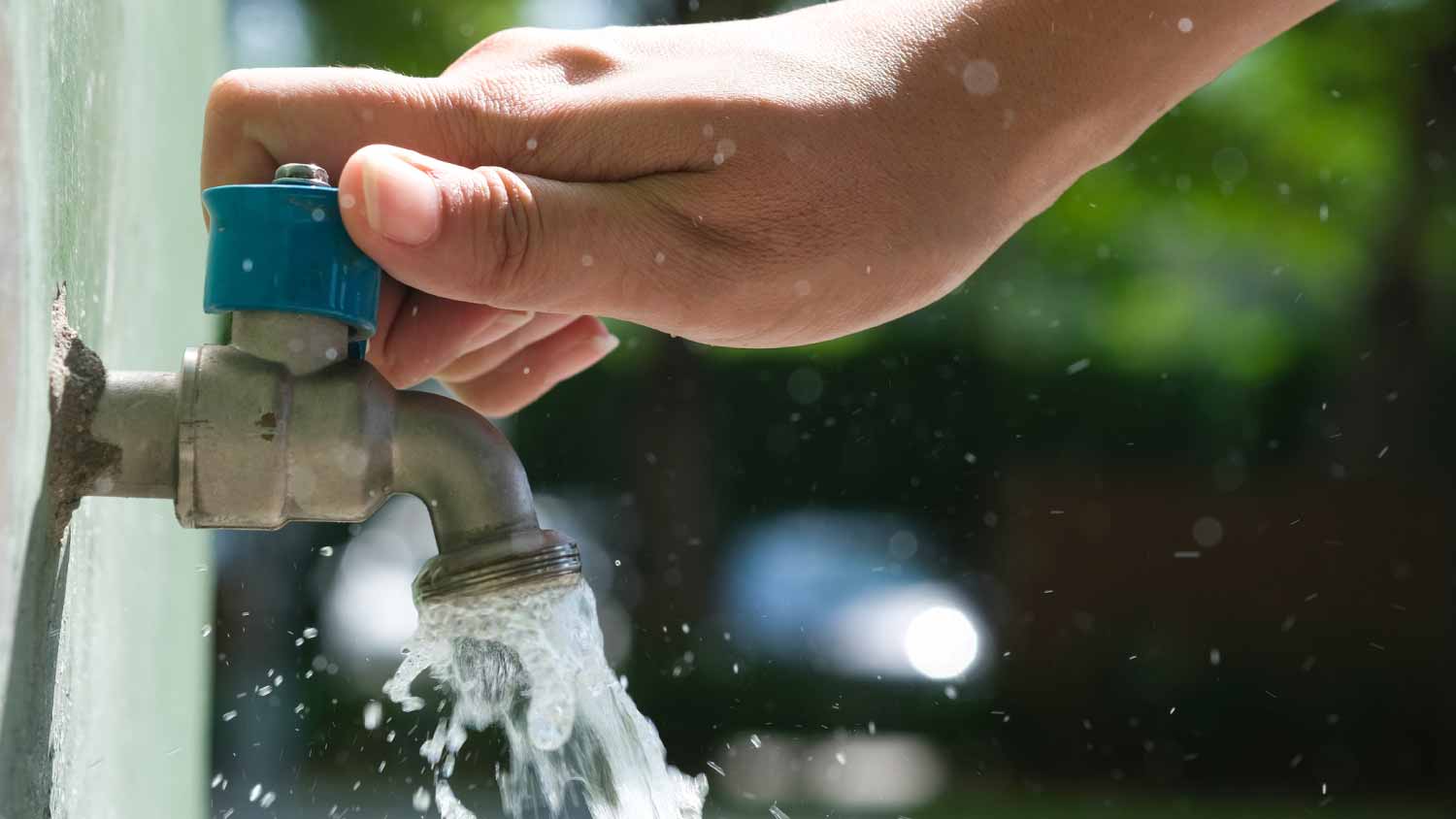 Woman opening faucet