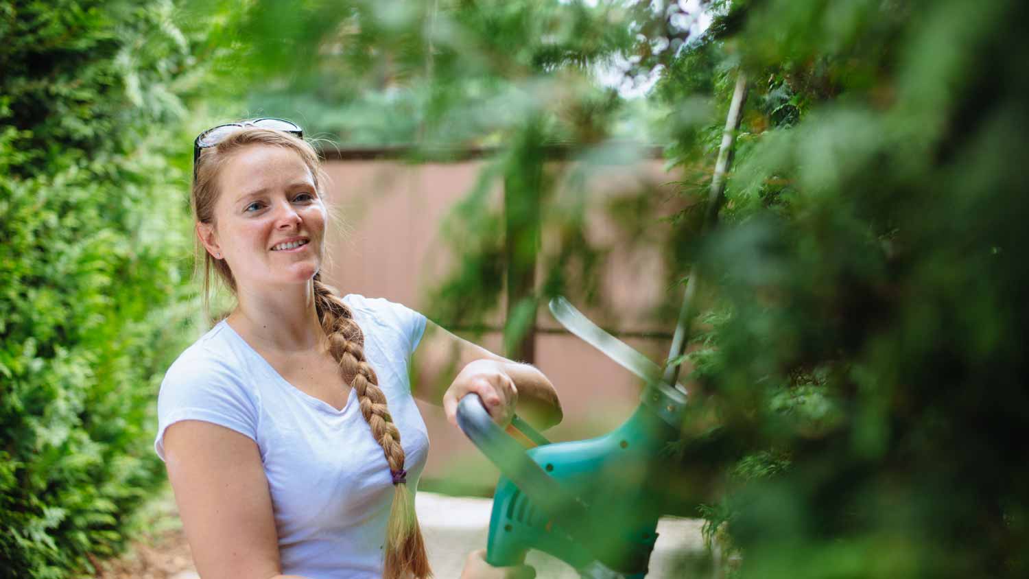Woman with hedge trimmer in the garden