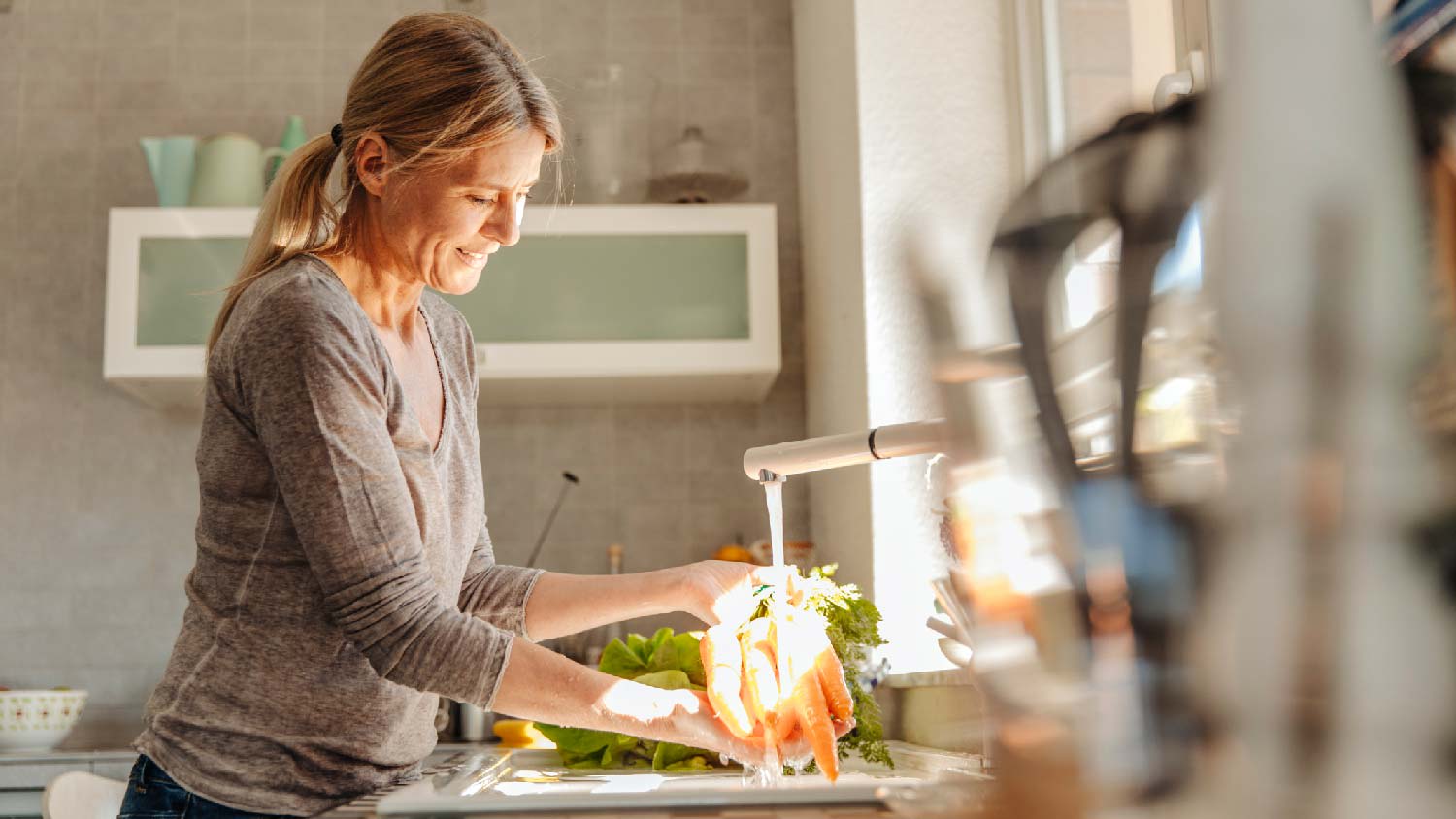 A woman washing vegetables in the sink