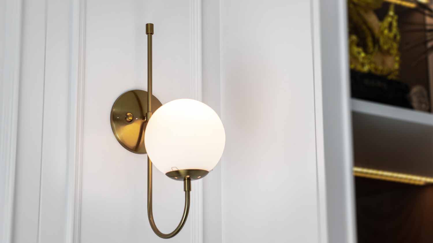Gold wall lamp on white wall
