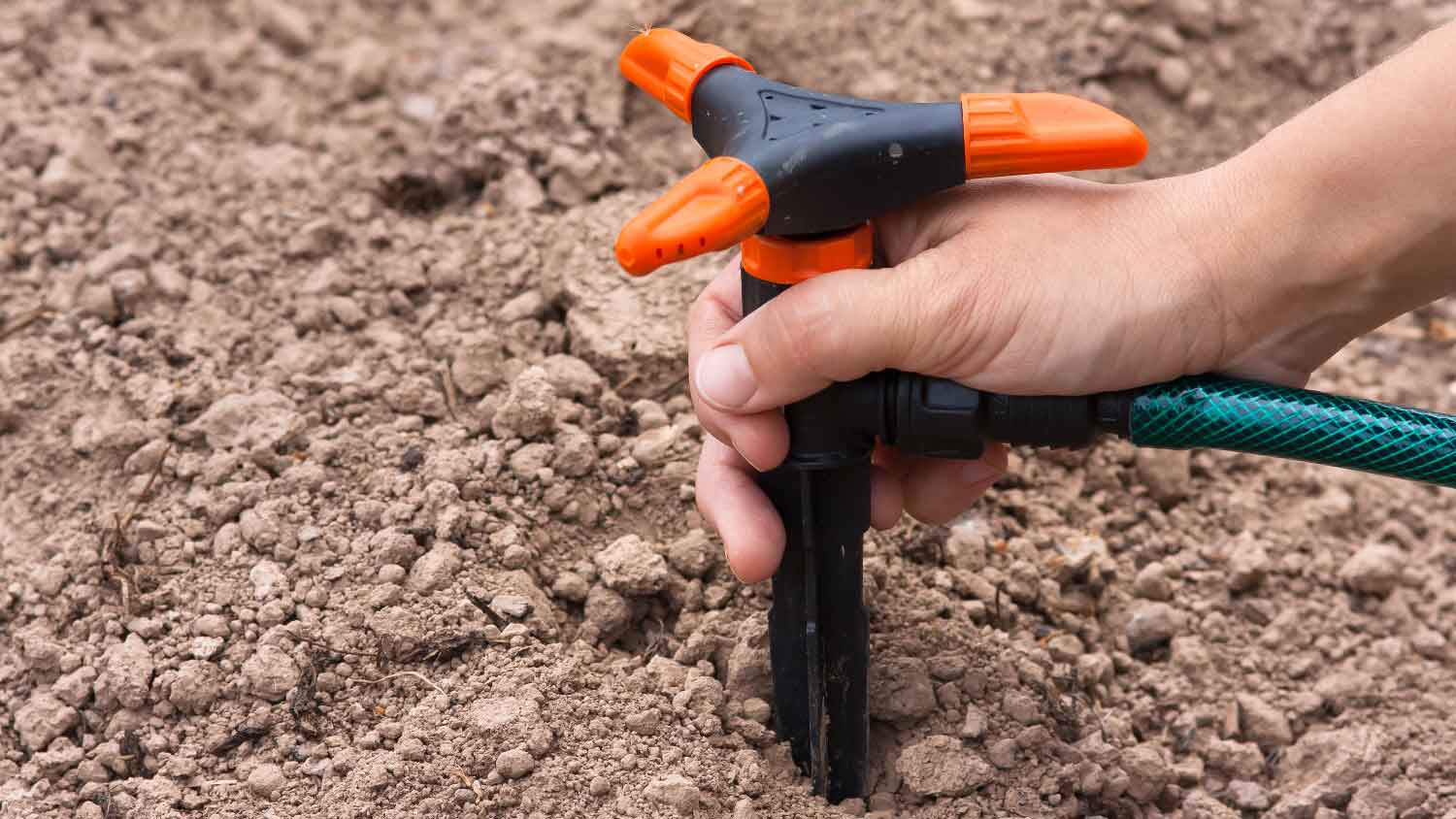 A person installing a sprinkler head