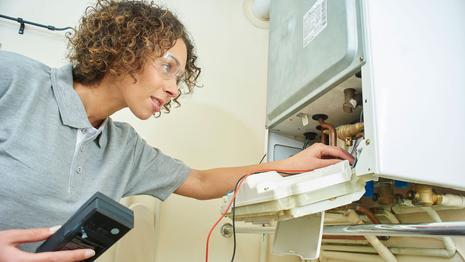 A plumber inspecting a boiler