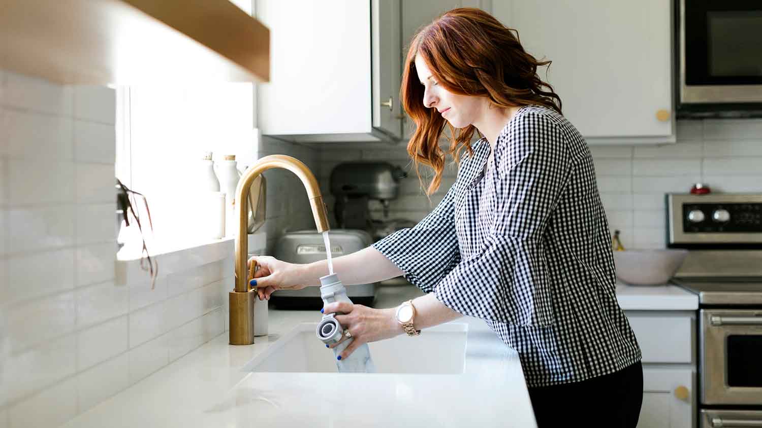 Woman filling bottle with tap water