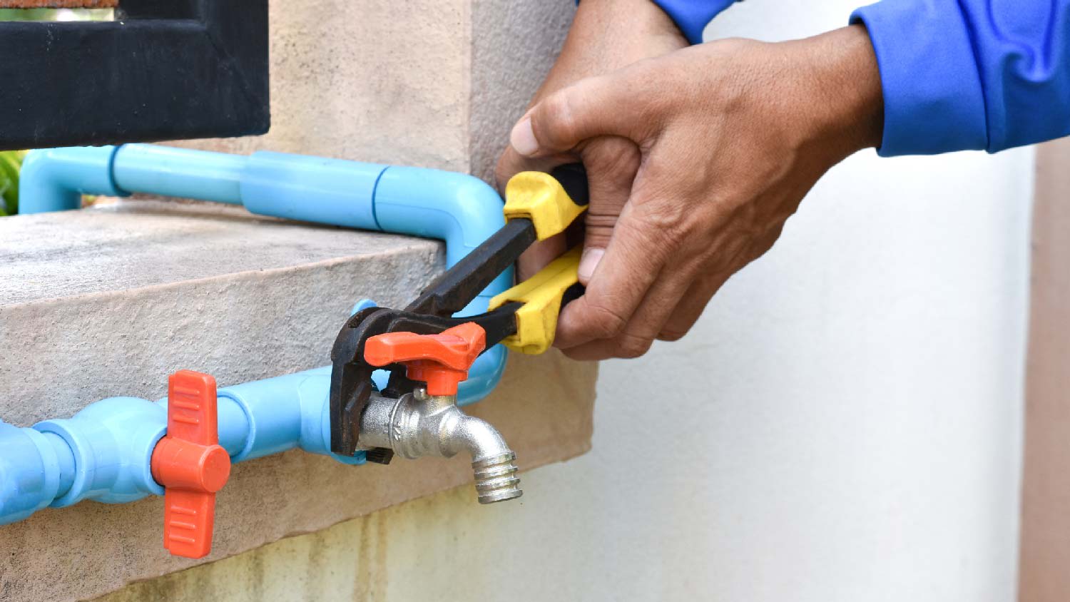 A man removing a sprinkler valve