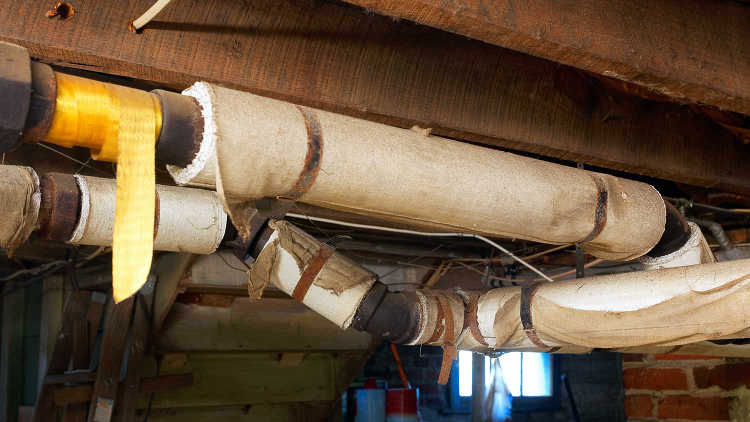 basement pipes wrapped in asbestos insulation