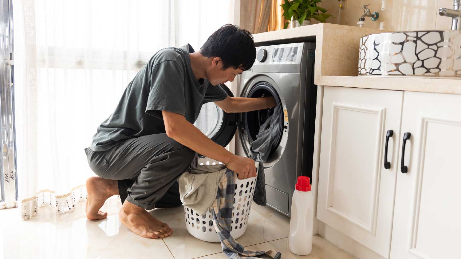 A young man loading the washing machine