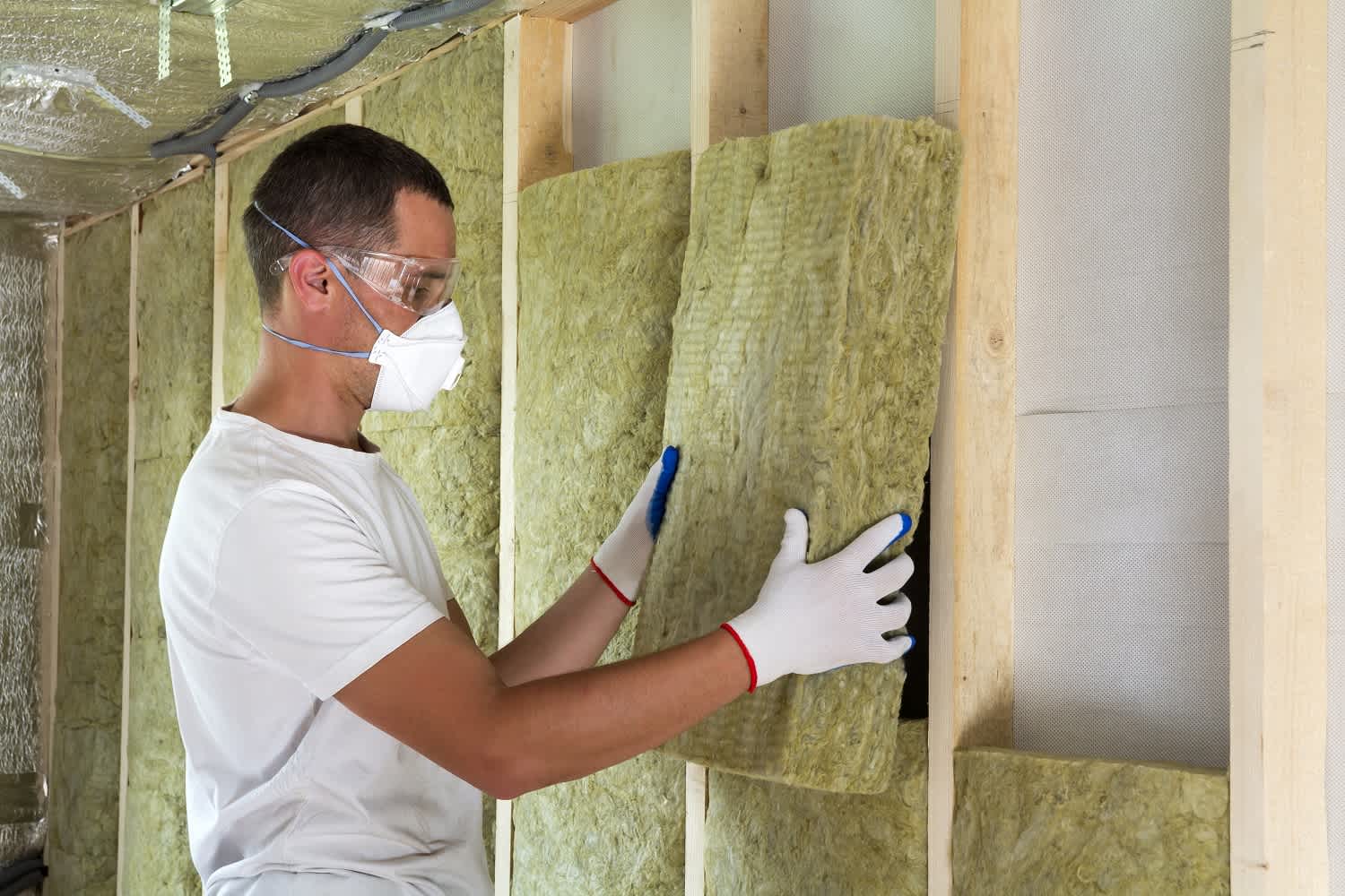 Man installing fiberglass insulation