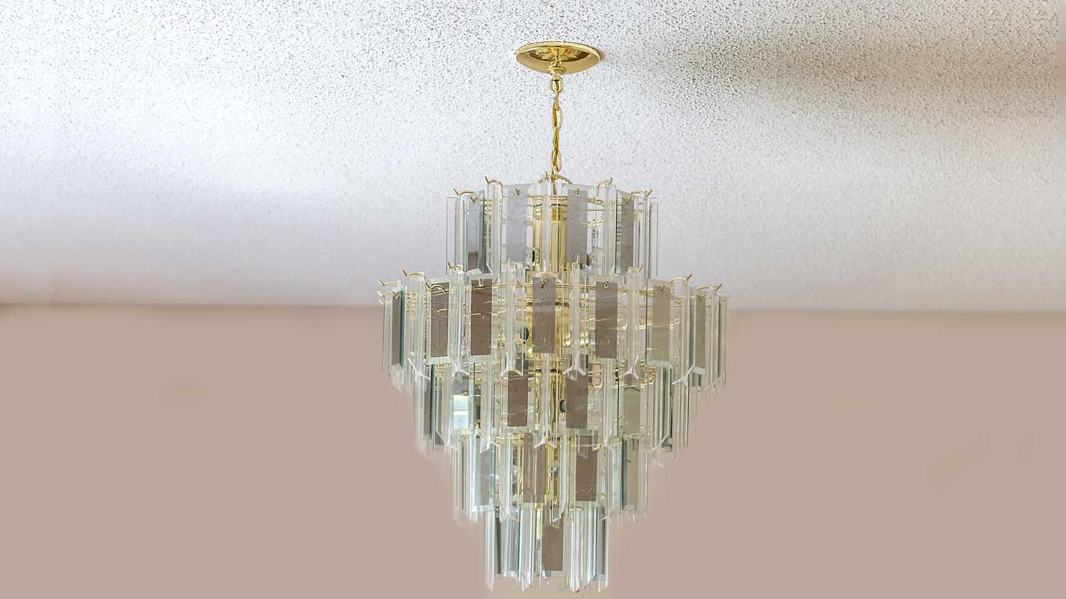 glass chandelier hanging from popcorn ceiling
