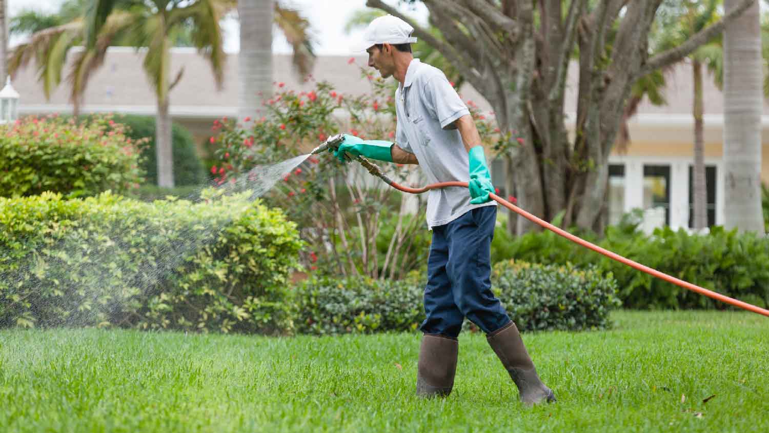 A worker doing liquid aeration to lawn